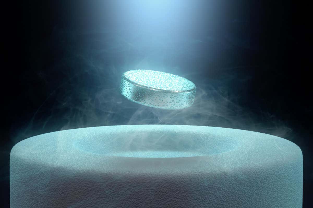 E8X75D Image concept of magnetic levitating above a high-temperature superconductor, cooled with liquid nitrogen.