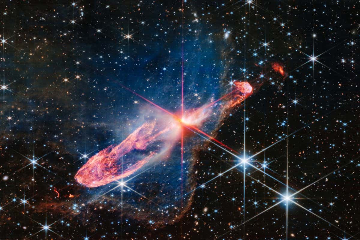 The NASA/ESA/CSA James Webb Space Telescope has captured a high-resolution image of a tightly bound pair of actively forming stars, known as Herbig-Haro 46/47, in near-infrared light. Look for them at the centre of the red diffraction spikes. The stars are buried deeply, appearing as an orange-white splotch. They are surrounded by a disc of gas and dust that continues to add to their mass. Herbig-Haro 46/47 is an important object to study because it is relatively young ??? only a few thousand years old. Stars take millions of years to form. Targets like this also give researchers insight into how stars gather mass over time, potentially allowing them to model how our own Sun, a low-mass star, formed. The two-sided orange lobes were created by earlier ejections from these stars. The stars??? more recent ejections appear as blue, thread-like features, running along the angled diffraction spike that covers the orange lobes. Actively forming stars ingest the gas and dust that immediately surrounds them in a disc (imagine an edge-on circle encasing them). When the stars ???eat??? too much material in too short a time, they respond by sending out two-sided jets along the opposite axis, settling down the star???s spin, and removing mass from the area. Over millennia, these ejections regulate how much mass the stars retain. Don???t miss the delicate, semi-transparent blue cloud. This is a region of dense dust and gas, known as a nebula. Webb???s crisp near-infrared image lets us see through its gauzy layers, showing off a lot more of Herbig-Haro 46/47, while also revealing a wide range of stars and galaxies that lie far beyond it. The nebula???s edges transform into a soft orange outline, like a backward L along the right and bottom of the image. The blue nebula influences the shapes of the orange jets shot out by the central stars. As ejected material rams into the nebula on the lower left, it takes on wider shapes, because there is more opportunity for the jets to interact with molecules within the nebula. Its material also causes the stars??? ejections to light up. Over millions of years the stars in Herbig-Haro 46/47 will form fully ??? clearing the scene. Take a moment to linger on the background. A profusion of extremely distant galaxies dot Webb???s view. Its composite NIRCam (Near-Infrared Camera) image is made up of several exposures, highlighting distant galaxies and stars. Blue objects with diffraction spikes are stars, and the closer they are, the larger they appear. White-and-pink spiral galaxies sometimes appear larger than these stars, but are significantly farther away. The tiniest red dots, Webb???s infrared specialty, are often the oldest, most distant galaxies. [Image description: At the centre is a thin horizontal orange cloud tilted from bottom left to top right. It takes up about two-thirds of the length of this angle, but is thin at the opposite angle. At its centre is a set of very large red and pink diffraction spikes in Webb???s familiar eight-pointed pattern. It has a central yellow-white blob, which hides two tightly orbiting stars. The background is filled with stars and galaxies.]