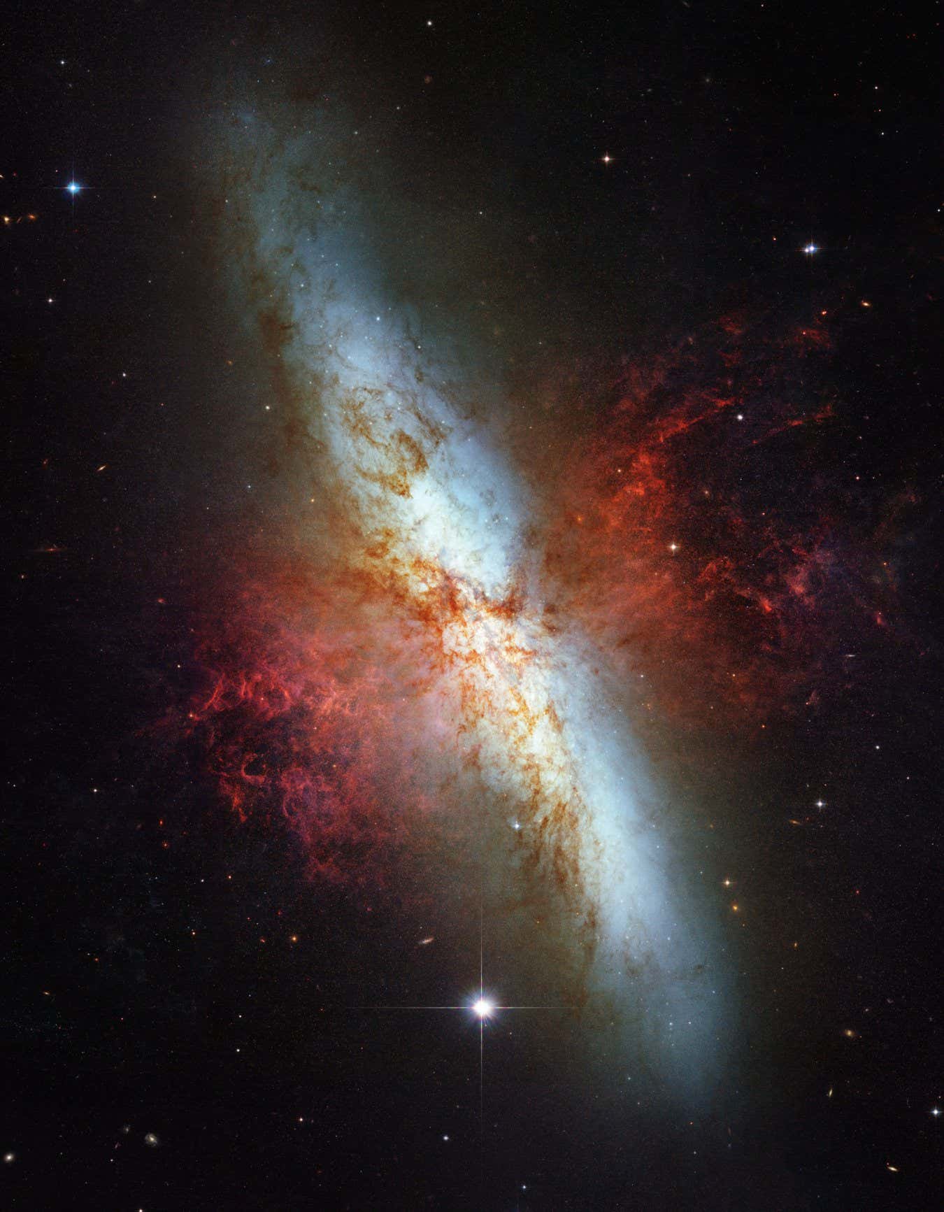 This mosaic image of the magnificent starburst galaxy, Messier 82 (M82) is the sharpest wide-angle view ever obtained of M82. It is a galaxy remarkable for its webs of shredded clouds and flame-like plumes of glowing hydrogen blasting out from its central regions where young stars are being born 10 times faster than they are inside in our Milky Way Galaxy.