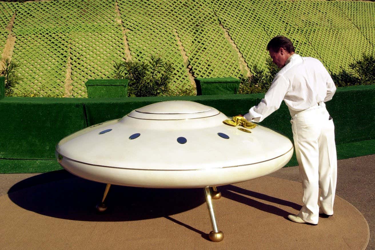 380363 03: William Protor polishes a model flying saucer on property near Jamul, CA, October 15, 2000, purchased by the Unarius Academy of Science to serve as a future landing site for 