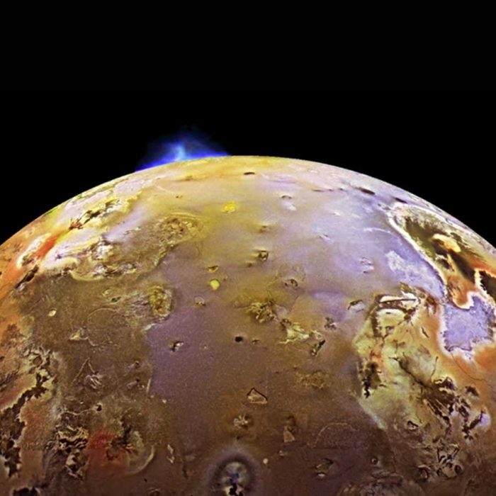 Synchronised volcanic eruptions on Io hint at a spongy interior