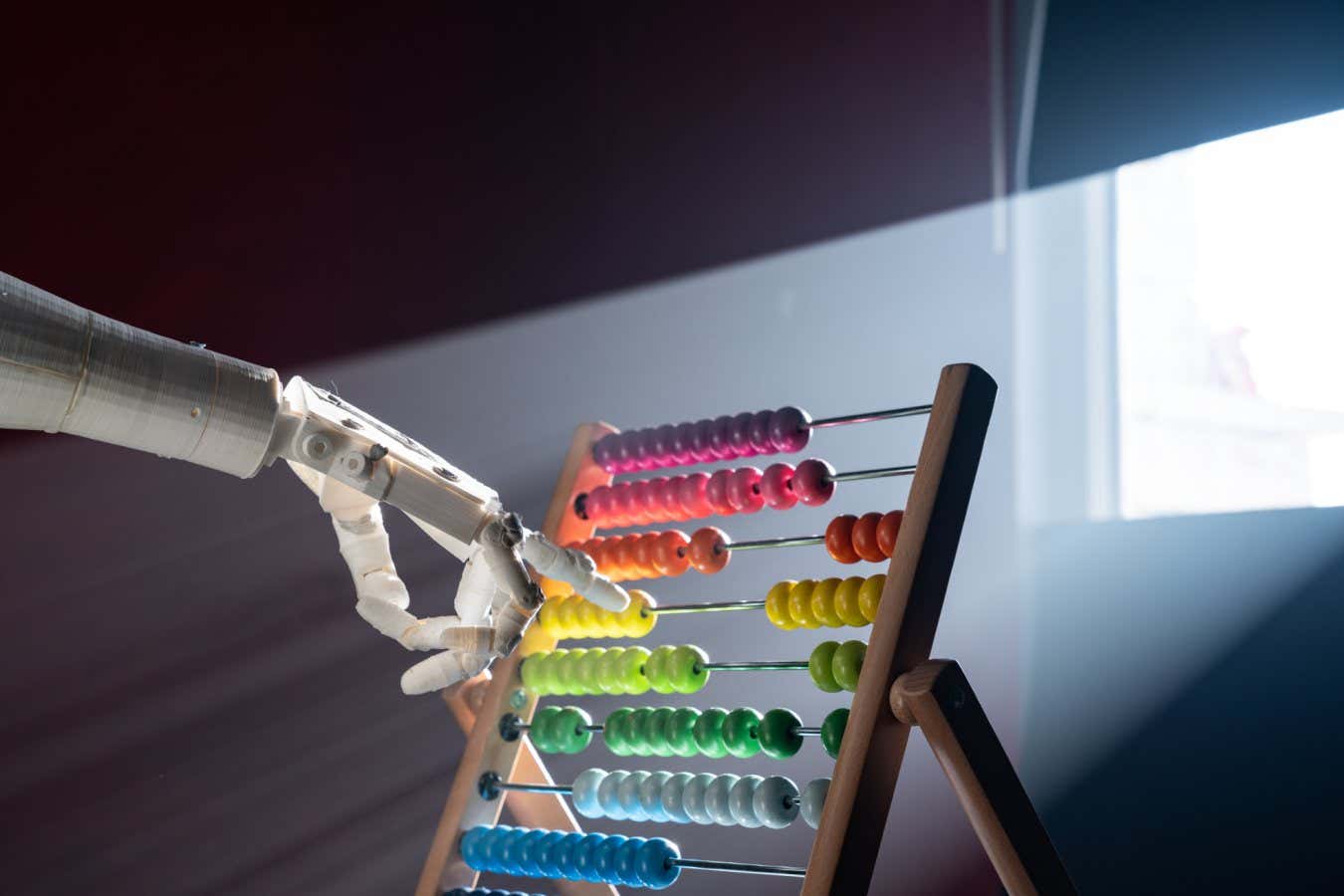 Robot using multi colored abacus under light beam. No people are seen in frame. Shot indoor with a full frame mirrorless camera.