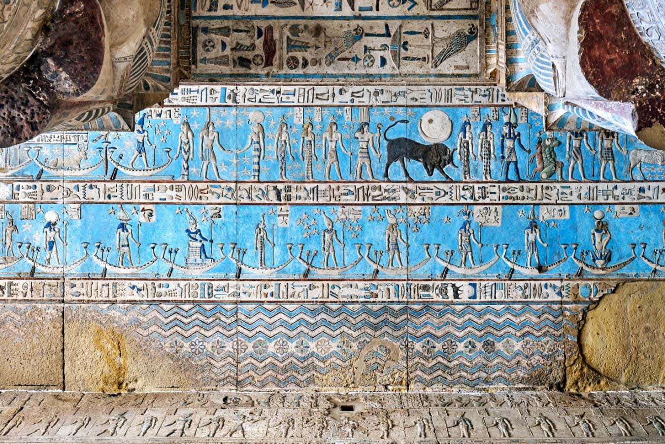 The Dendera Temple complex in Qena. A bright blue paint is used to highlight hieroglyphic carvings on a wall.