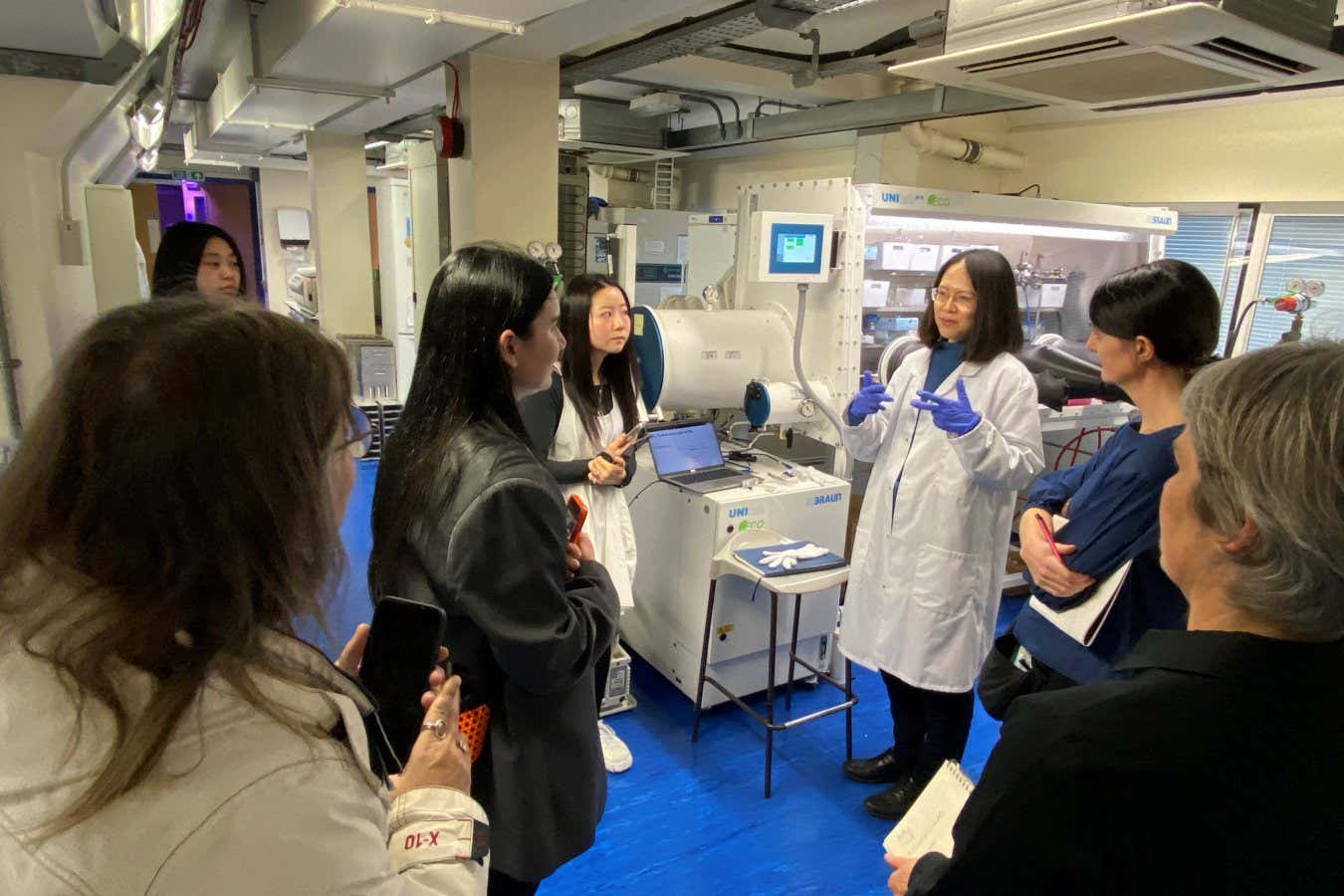 Researcher Feixue Liu at her lab in University Collge London, explaining the equipment to students