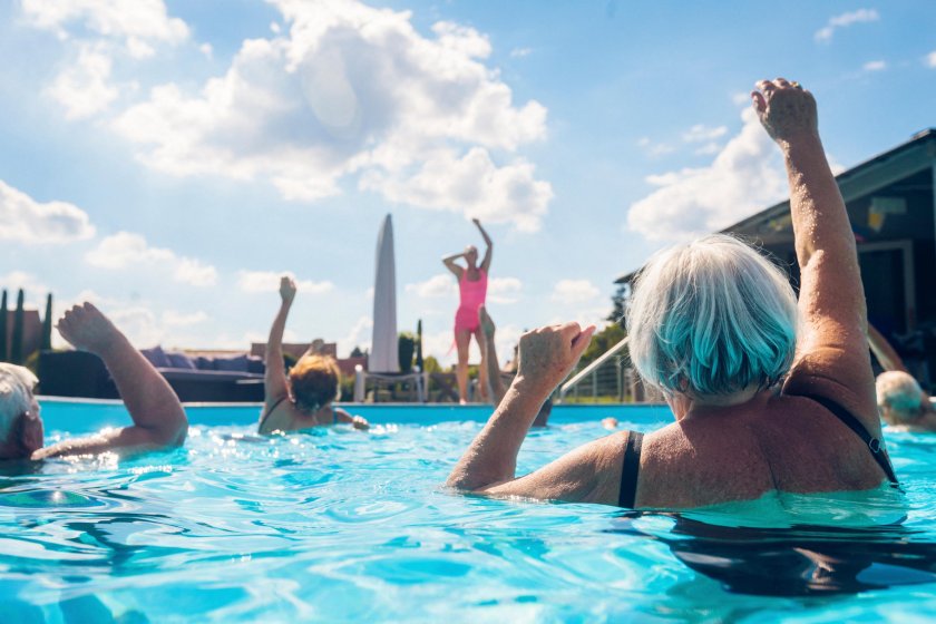 KJG7DK Group of seniors with trainer doing water gymnastics in pool