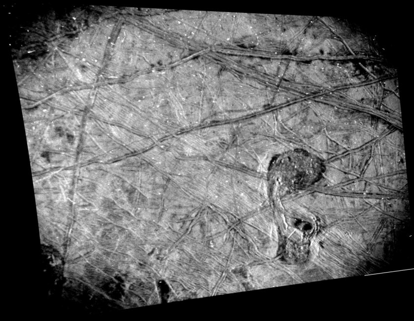 This black-and-white image of Europa's surface was taken by the Stellar Reference Unit (SRU) aboard NASA's Juno spacecraft during a Sept. 29, 2022, flyby of the Jovian moon. The image shows a region crisscrossed with a network of fine grooves and sets of complicated double ridges (pairs of long parallel lines indicating elevated features in the ice). In the upper right corner are dark stains possibly linked to cryovolcanic plume activity (the bubbling up of liquid from beneath the ice). Just below center and to the right is a surface feature that members of the Juno science team refer to as "the Platypus."