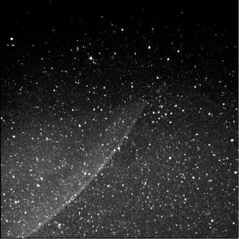Black and white image of a starry sky, with Jupiter's thin, translucent rings