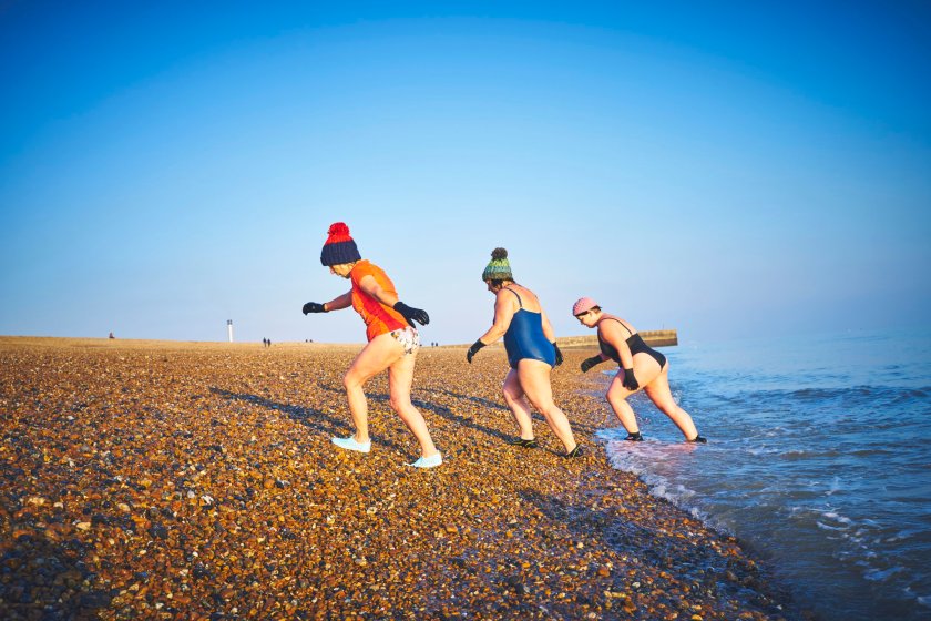 Family emerging from the sea in winter after a swim
